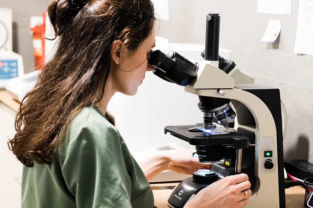 Lekarka weterynarii ocenia próbkę pod mikroskopem w laboratorium kliniki VETKA