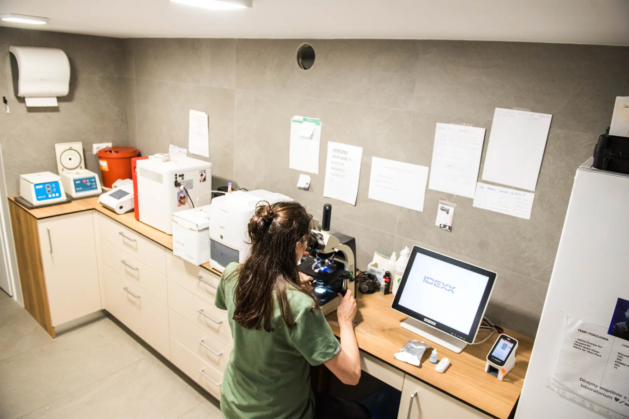 Laboratorium kliniki — technik przy mikroskopie i analizatorach