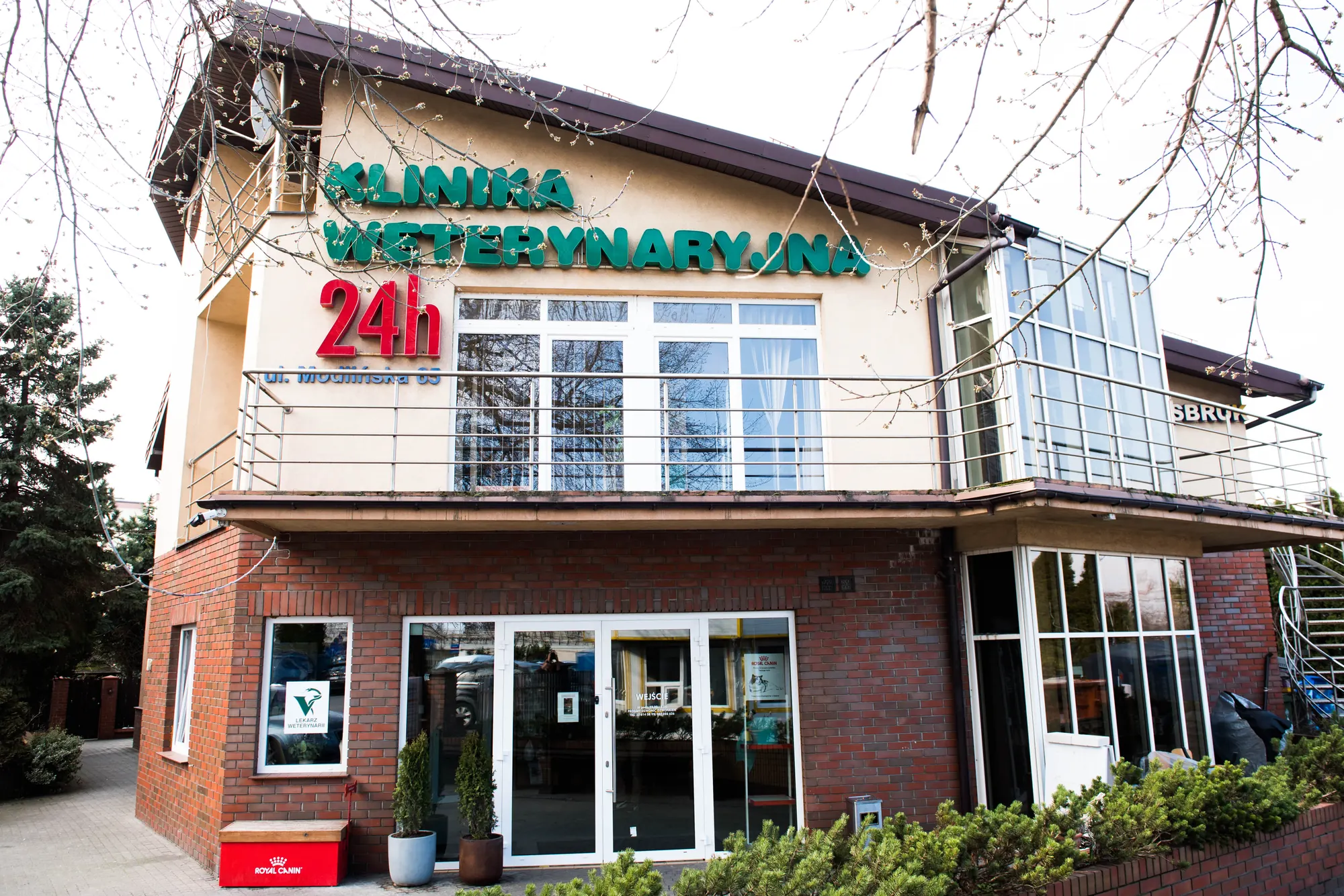 Wejście do Kliniki VETKA z podświetlanym szyldem „Klinika Weterynaryjna 24h”